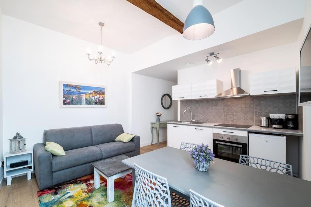 une cuisine et un salon avec un canapé et une table dans l'établissement Le Shabby Chic, Beau T2, Patio, Centre Ville, à Montpellier