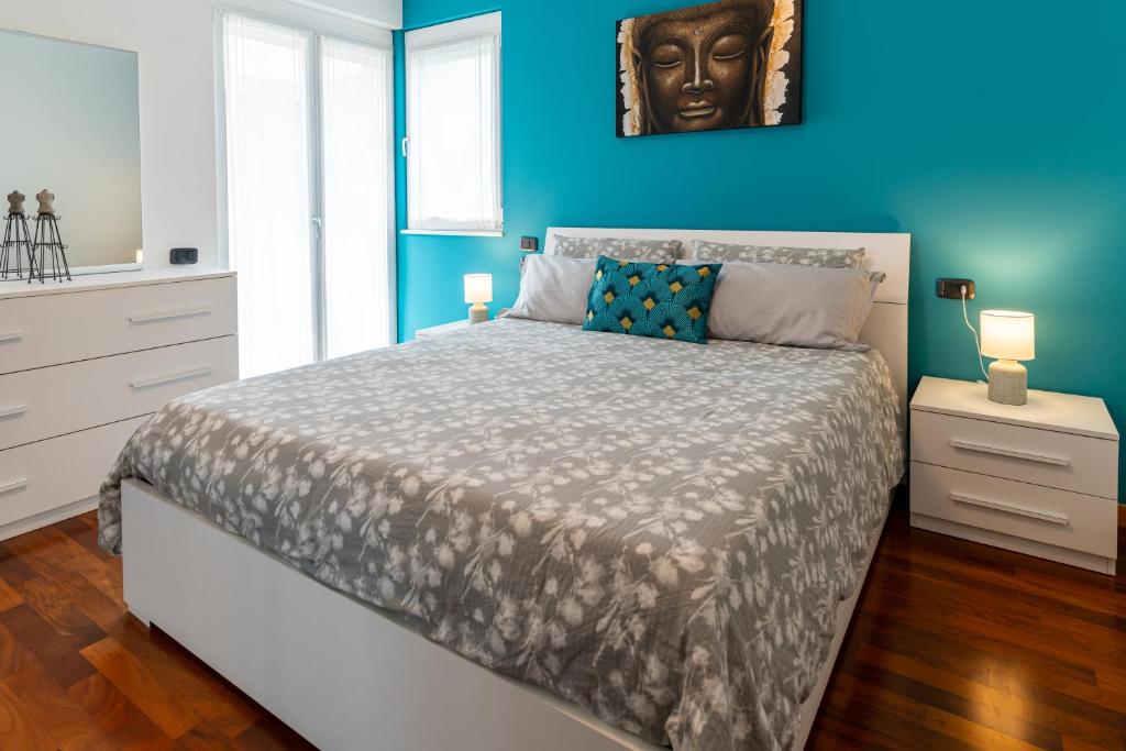 1 dormitorio con 1 cama grande y pared azul en Casa Cassiopea, en Riva del Garda