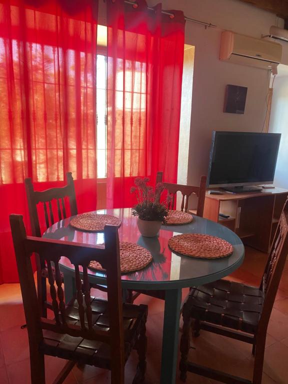 a dining room with a table and chairs and red curtains at Apartamento Nora in Iznate