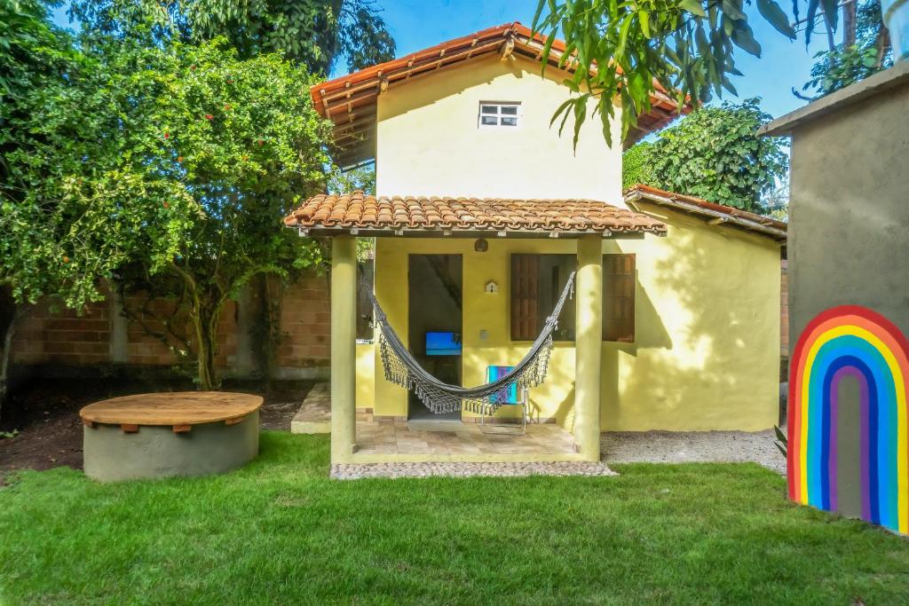 a play house with a hammock in the yard at Bangalô Arco Íris (Quadrado Trancoso) in Trancoso