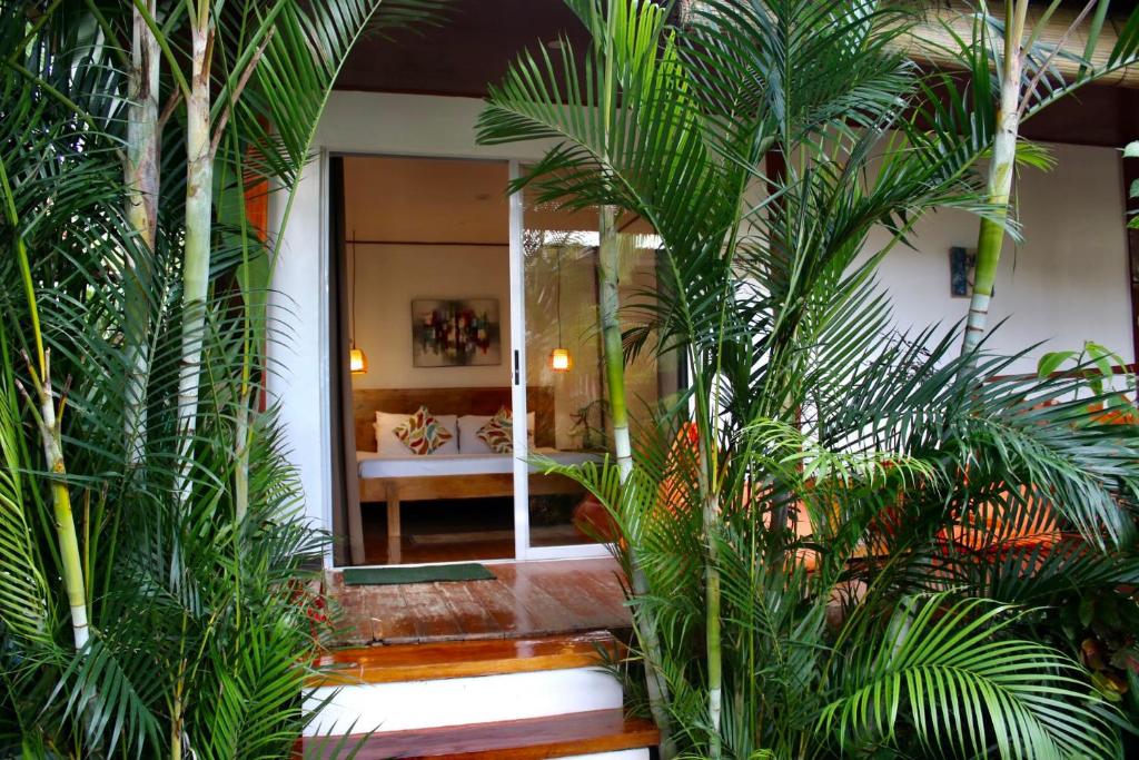 a room with palm trees and a mirror at Bella Athena Garden in El Nido