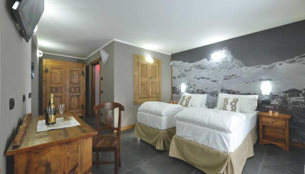 a hotel room with a bed and a desk and a room at Mollino Rooms by Skilink (Winter) in Breuil-Cervinia