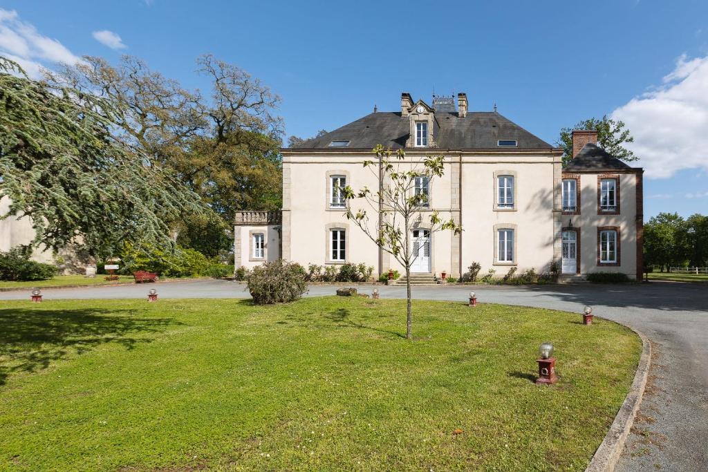 una gran casa blanca con un árbol en el patio en CHATEAU DE LA RICHERIE, en Beaurepaire