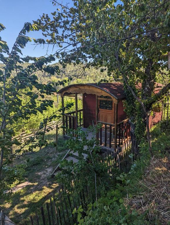 une petite maison avec une clôture dans un champ dans l'établissement roulotte à la mauvaise herbe, à Barjols