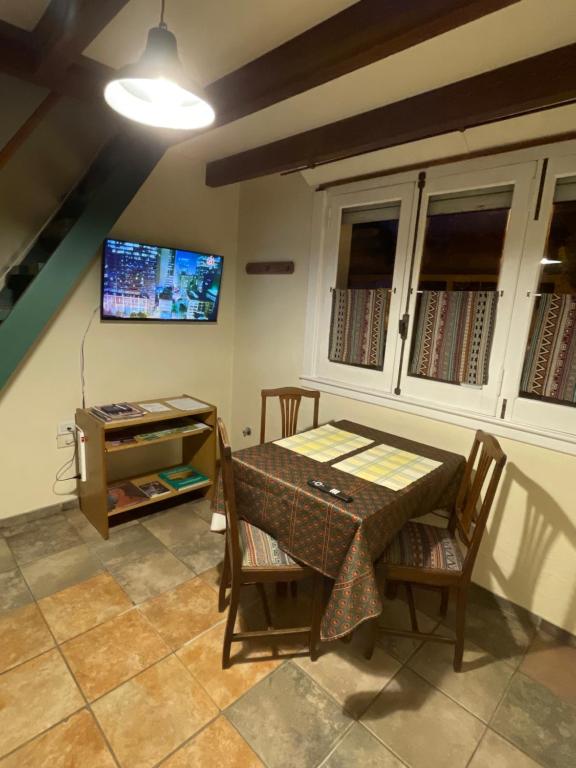 ein Esszimmer mit einem Tisch und einem TV in der Unterkunft Exquisito departamento “Boutique” in Balcarce