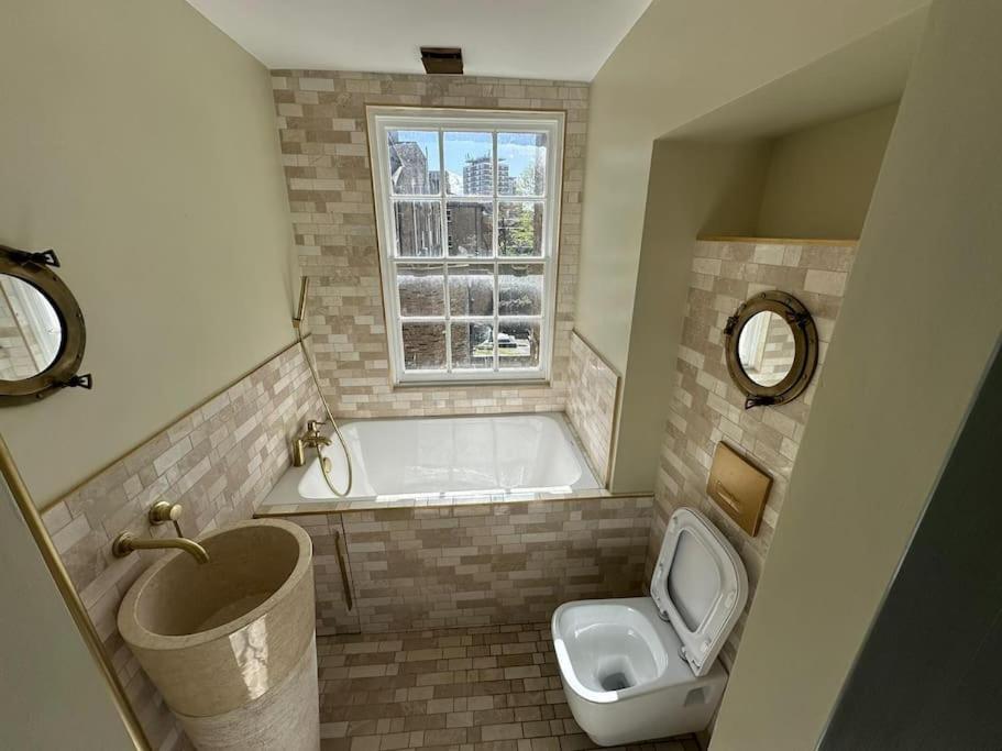 a bathroom with a tub and a toilet and a sink at Nice flat near Church Street in London