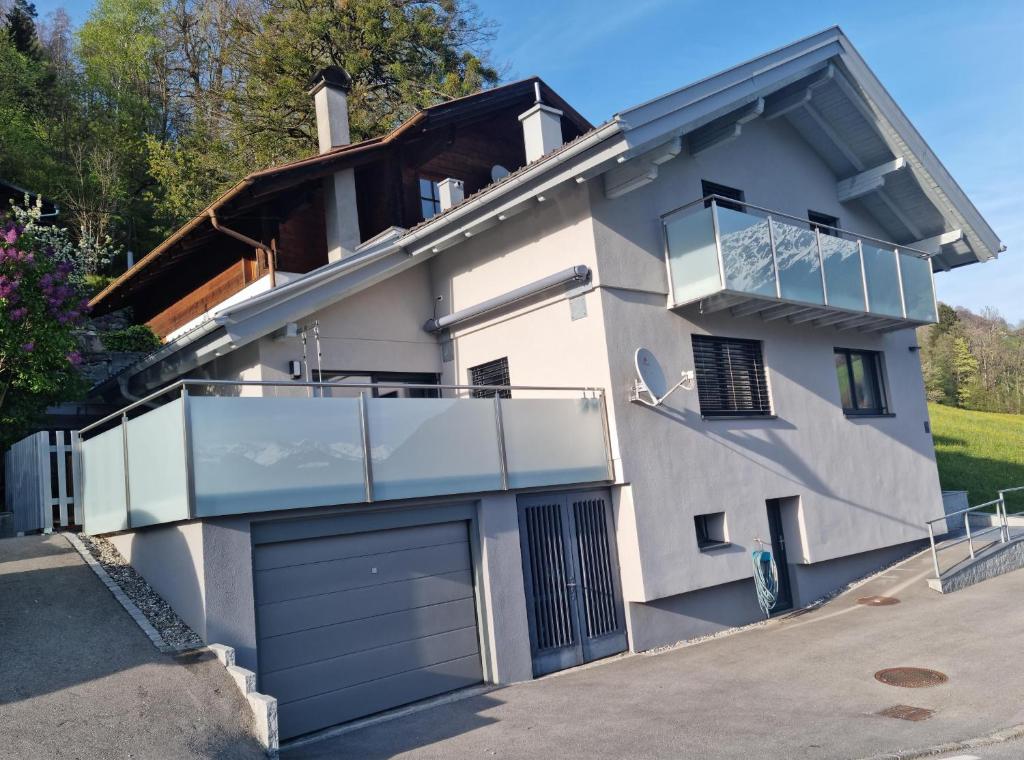 Cette maison blanche dispose d'un balcon et d'un garage. dans l'établissement Haus Fernweh, à Bartholomäberg