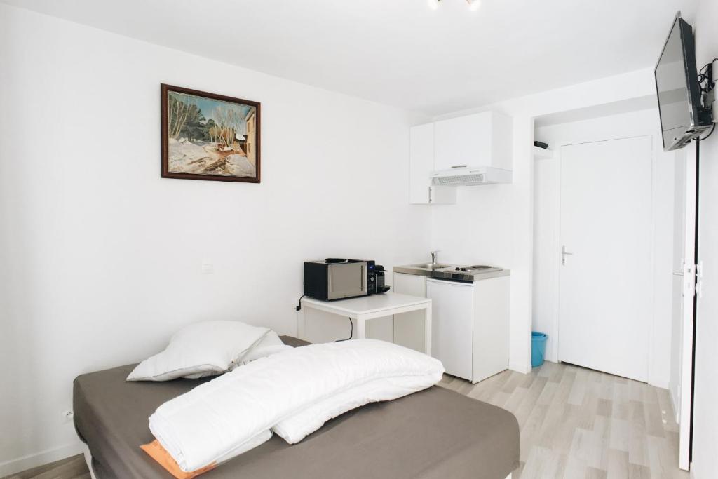 Cette chambre blanche dispose d'un lit et d'un four micro-ondes. dans l'établissement 19m2 Studio with air conditioning In The 15th, à Paris