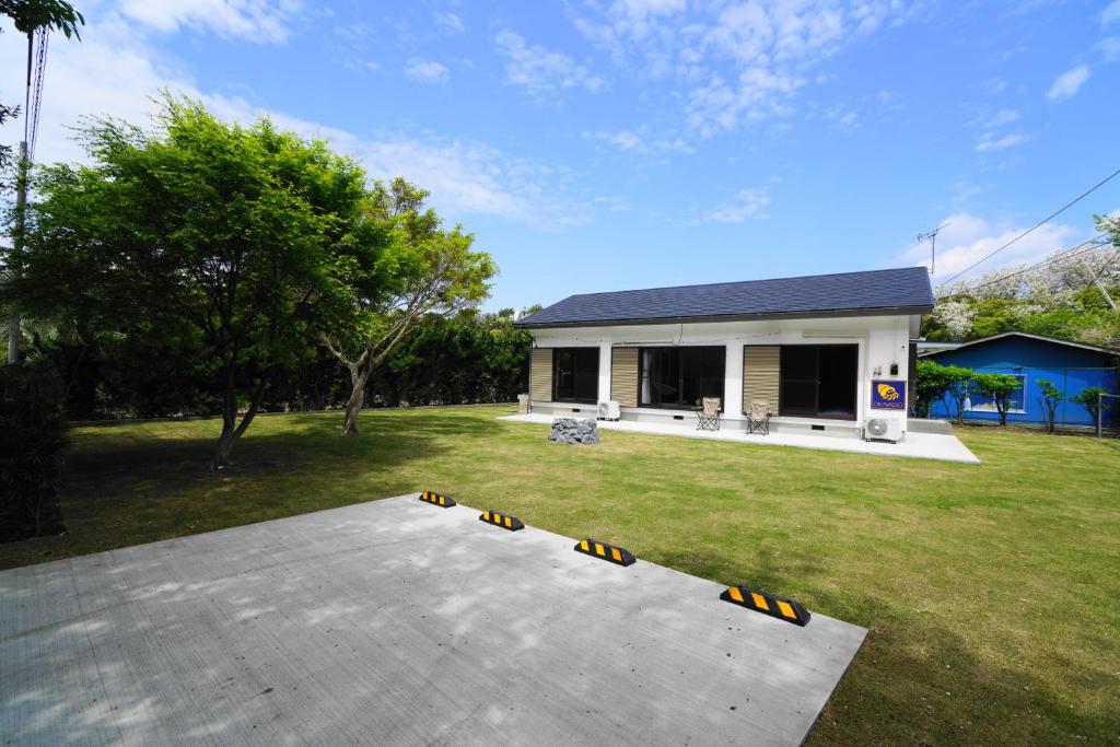 ein Haus mit einer Rolltreppe im Hof in der Unterkunft 一棟貸しの宿 OKAYADO in Oshima