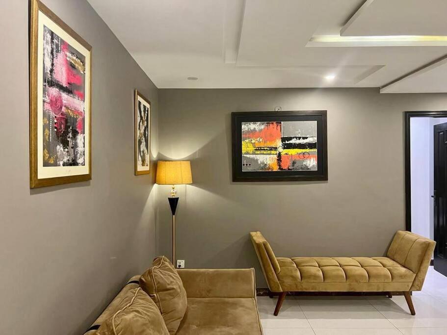 a living room with a couch and a lamp at 401-NEXT INN Quality Living Starts Here! in Lahore