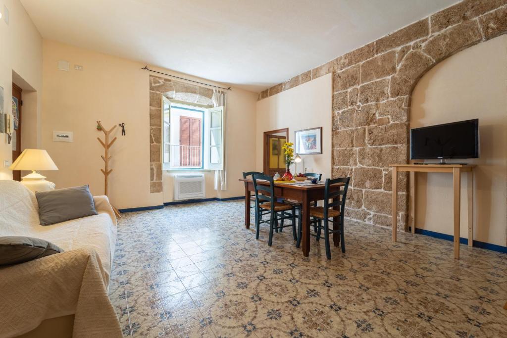 a living room with a table and a tv at Burantì Guest House in Alghero