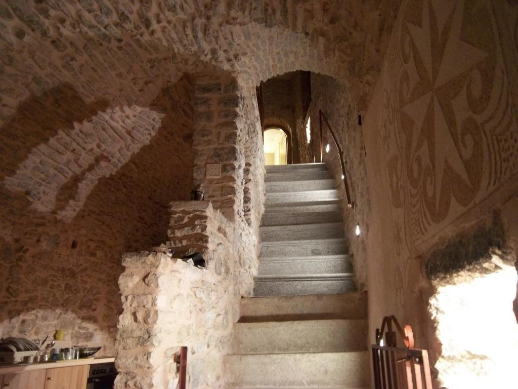 a staircase in a building with a stone wall at Traditional Guest house Chrisyis in Pyrgi