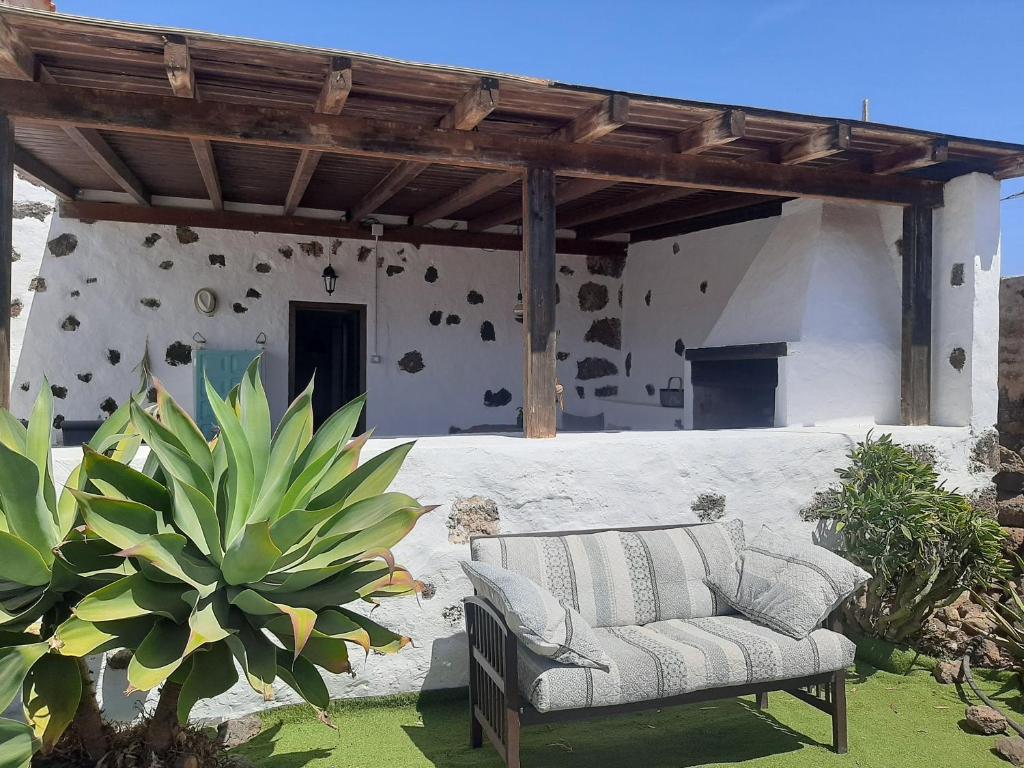 a couch sitting under a pergola on a patio at Sunset Terrace in La Oliva