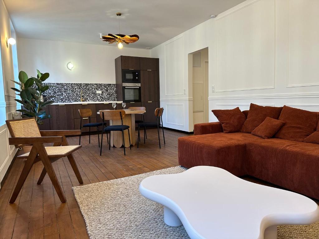 een woonkamer met een bruine bank en een keuken bij Reims Cathédrale Hyper Centre in Reims