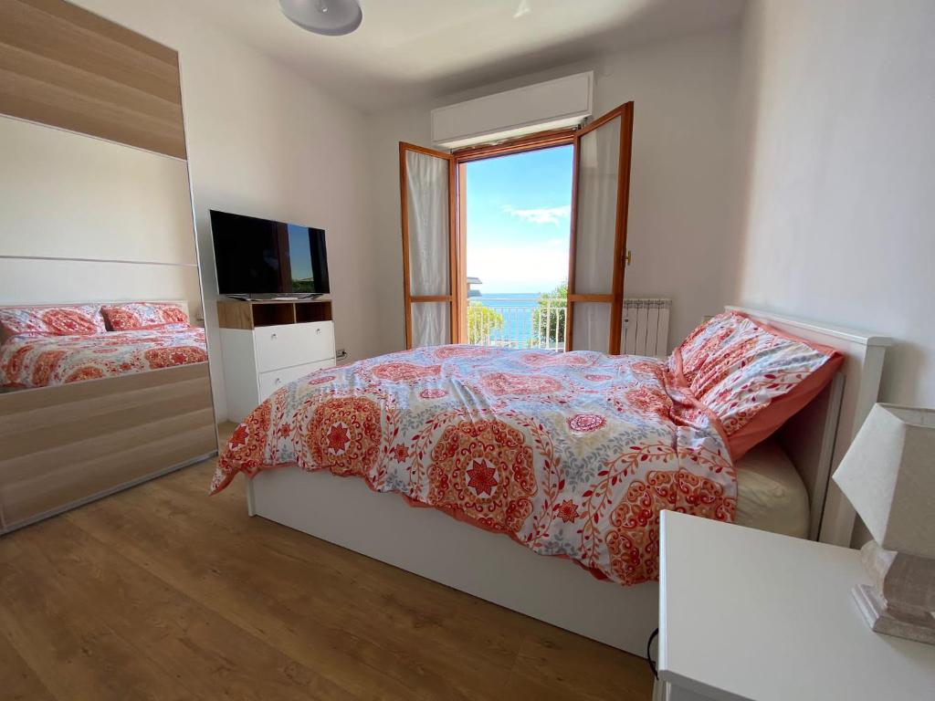 - une chambre avec un lit, une télévision et une fenêtre dans l'établissement Moderna Casa Fronte Mare, à Cogoleto