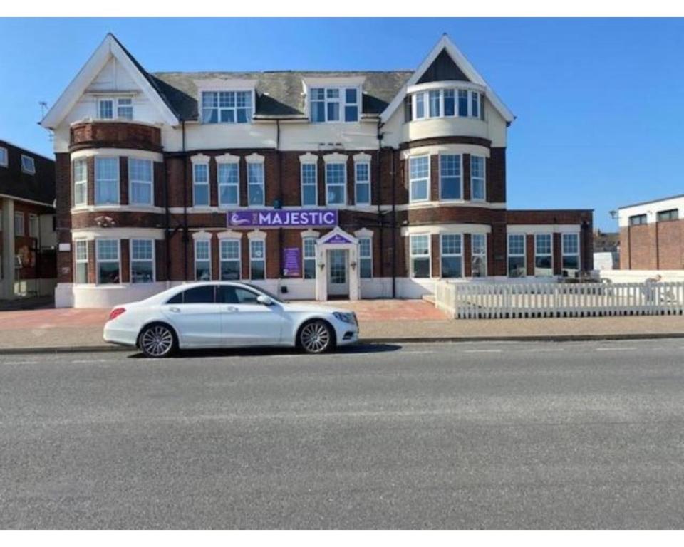 een witte auto geparkeerd voor een gebouw bij The Majestic in Great Yarmouth