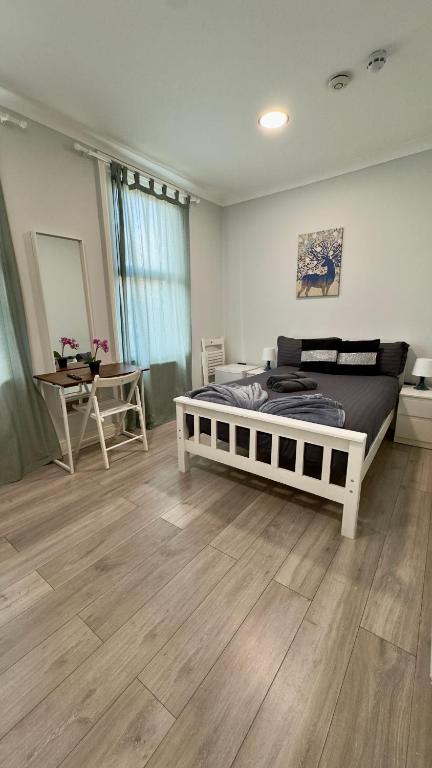 a bedroom with a large bed and a wooden floor at Guest&Rest 11 in London