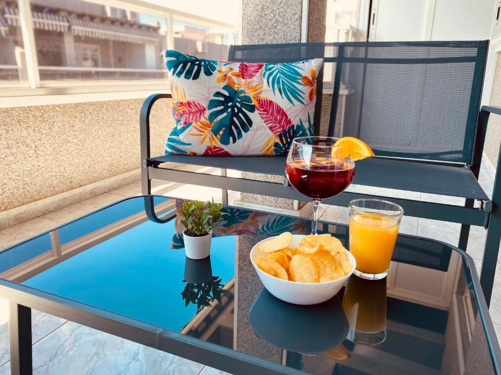 Una mesa de cristal con una copa de vino y un cuenco de pan. en Sunny Penthouse close to everything, en Torrevieja