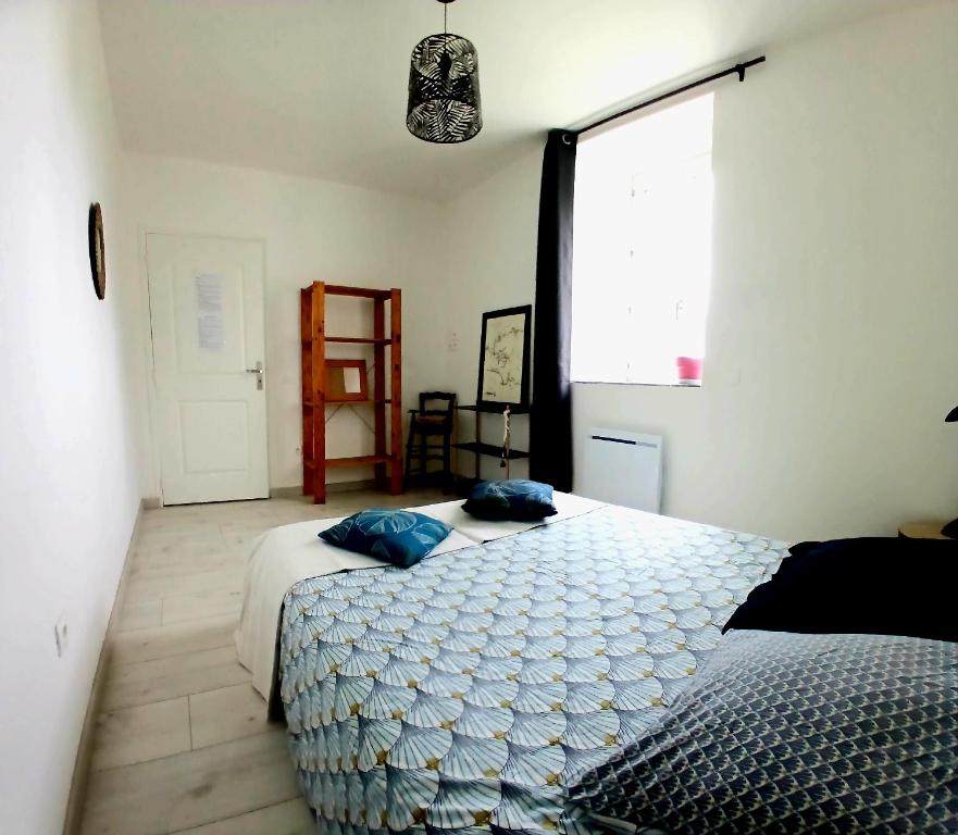 1 Schlafzimmer mit 2 Betten und einem großen Fenster in der Unterkunft Manoir de kerozet - Chambres chez l'habitant in Plouider