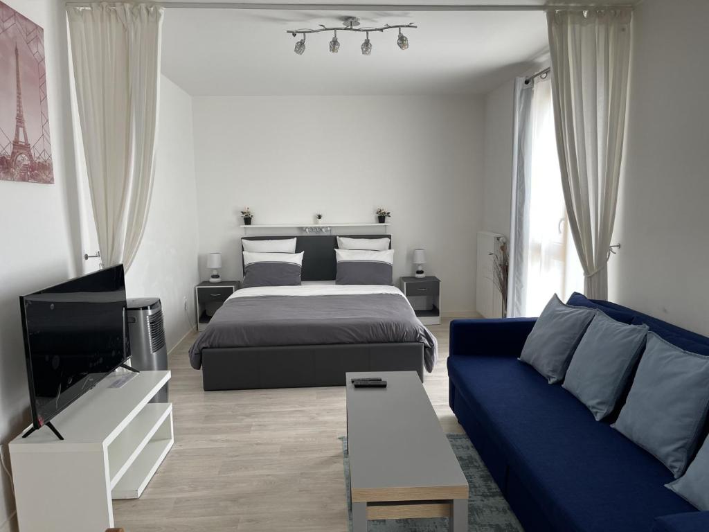 um quarto com uma cama e um sofá azul em HOUSE COSY ONE em Gonesse