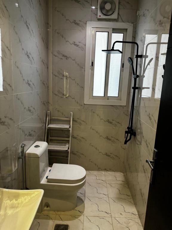 a bathroom with a toilet and a window at شقة انيقة بحي المنار in Jeddah