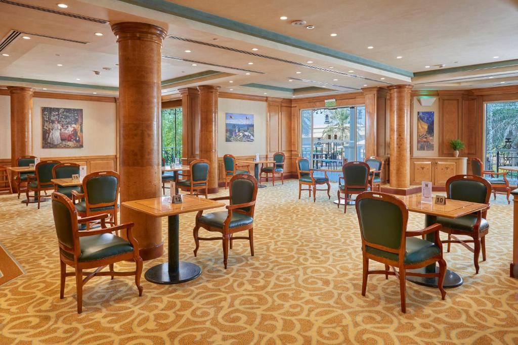 a restaurant with tables and chairs in a room at Crowne Plaza Bahrain by IHG in Manama