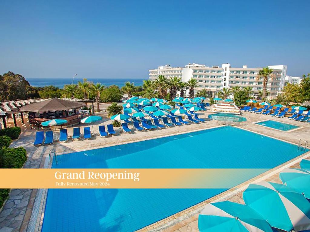 a large swimming pool with blue and white umbrellas and chairs at Sanders Florida in Ayia Napa