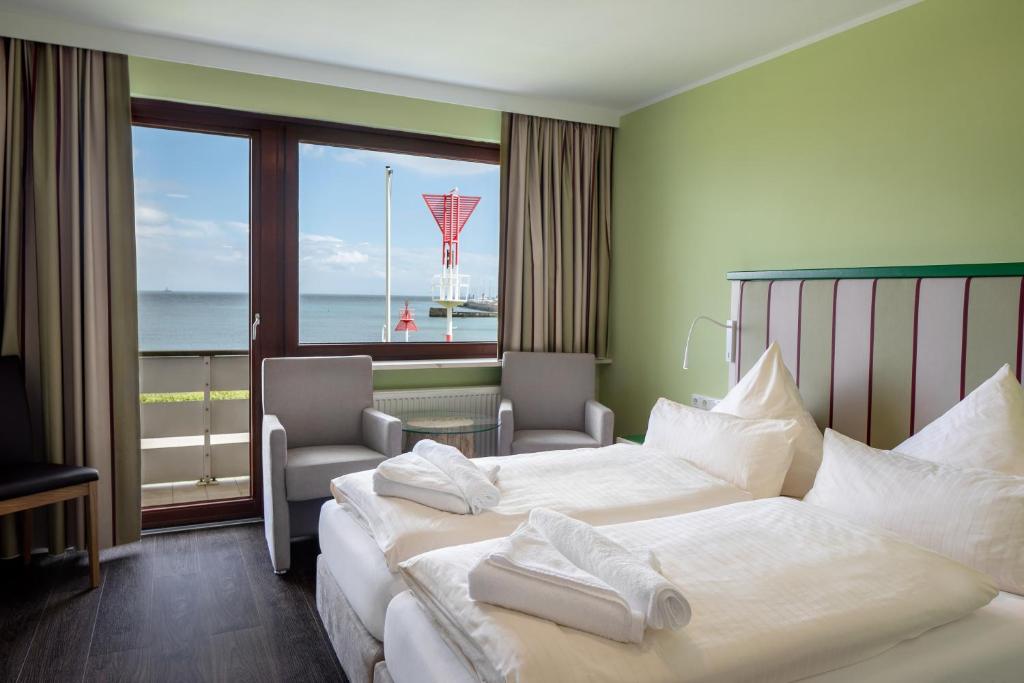 a hotel room with two beds and a view of the ocean at Insulaner Dependance in Helgoland