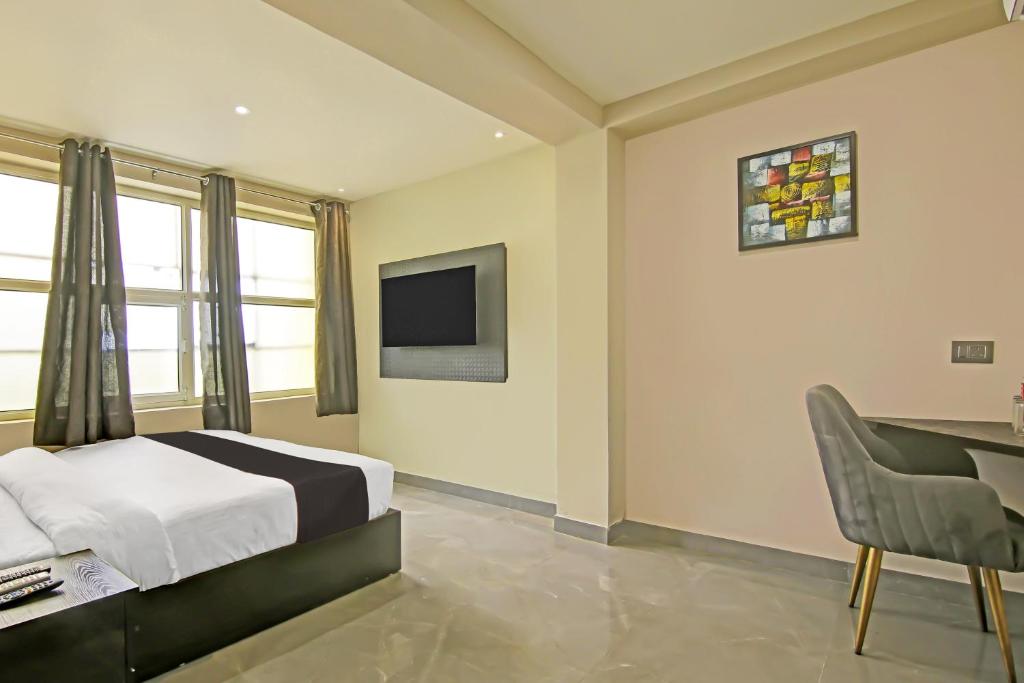 a bedroom with a bed and a desk and a television at Collection O Tunight in Ghaziabad