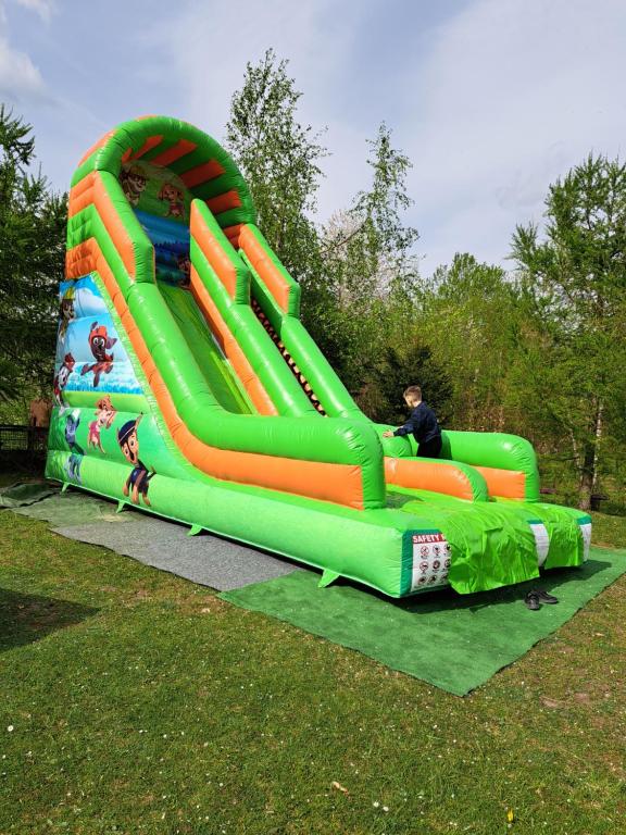 a boy is playing on a water slide in a park at Gospodarstwo Zacisze in Kowary
