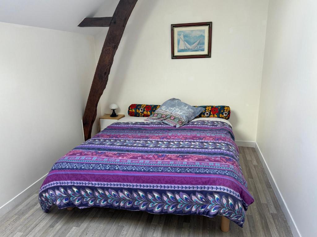 a bedroom with a bed with a colorful blanket at calme et verdure in La Bazouge-de-Chemeré