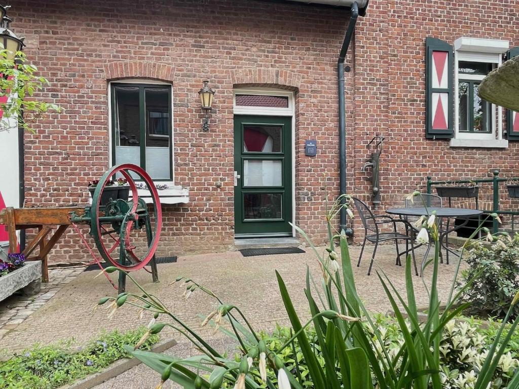 un patio con tavolo, sedie e un edificio di Luxe voor 2 in het heuvelland-De Trekvogel a Vijlen