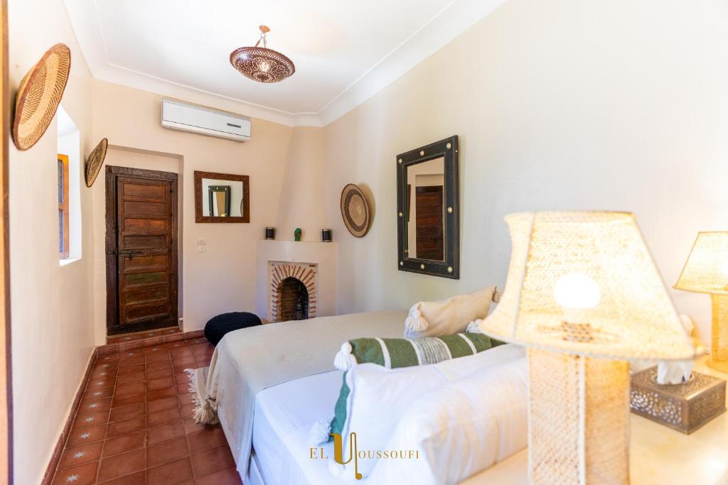 a bedroom with a bed and a lamp and a fireplace at Riad El Youssoufi in Marrakesh