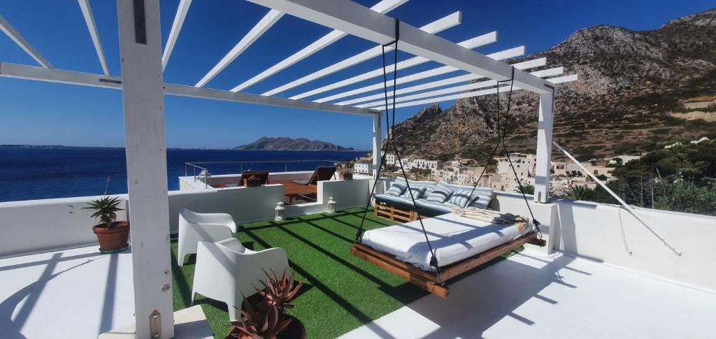 a balcony with a bed and a view of the ocean at La Casa di Azul in Levanzo