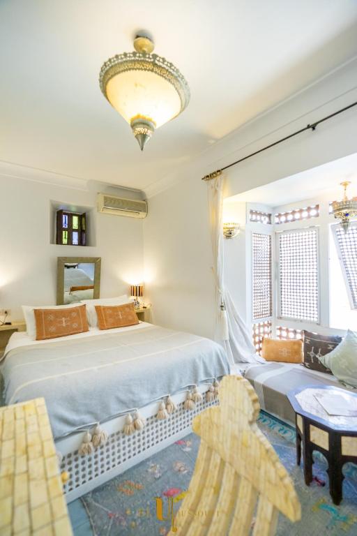 a bedroom with a large bed and a chandelier at Riad El Youssoufi in Marrakesh