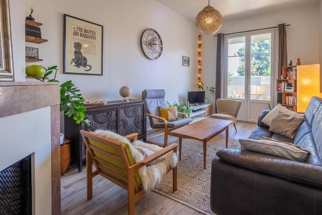 un salon avec un canapé et une cheminée dans l'établissement Le Vintage, Beau T3, Clim, Terrasse, Centre ville, à Montpellier