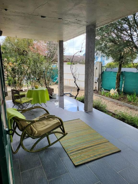 une terrasse couverte avec 2 chaises et une table. dans l'établissement Maison de charme à Vétraz-Monthoux - Terrasse, à Vétraz-Monthoux