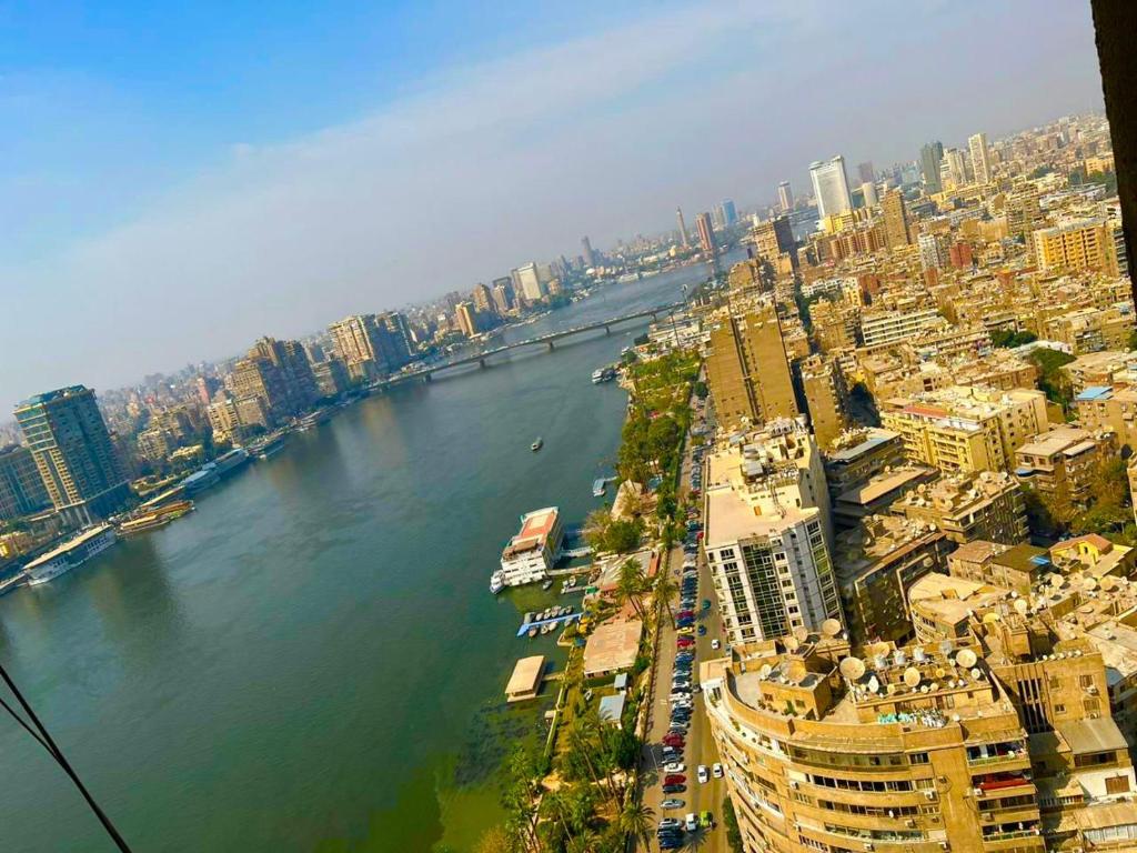 uitzicht op een rivier in een stad met gebouwen bij Nile Vibes Hotel in Caïro