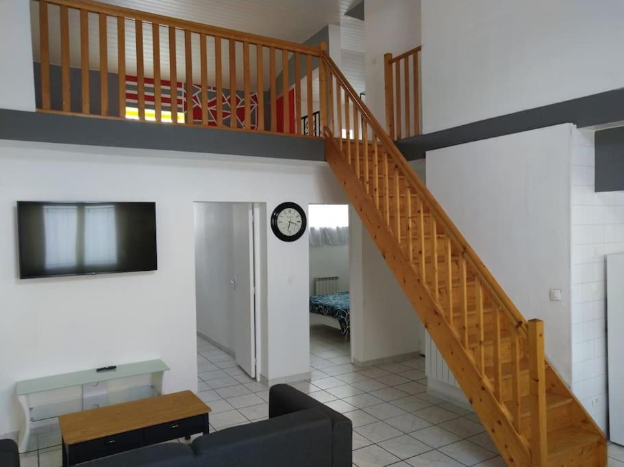 un salon avec un escalier et un canapé dans l'établissement Spacieuse maison avec garage 5 mins valenciennes, à Anzin
