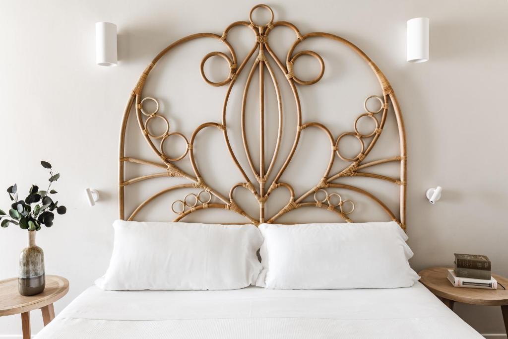 a bed with a large metal headboard with white pillows at Seebay Hotel in Portonovo