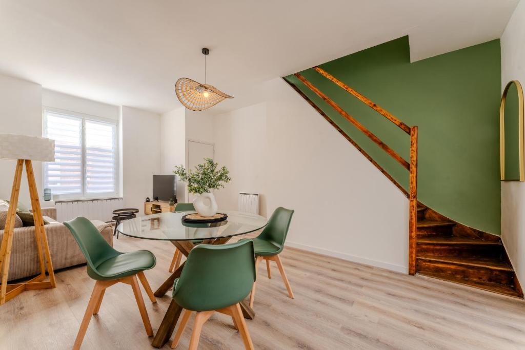 - un salon avec une table et des chaises vertes dans l'établissement Maison à Roubaix, à Roubaix