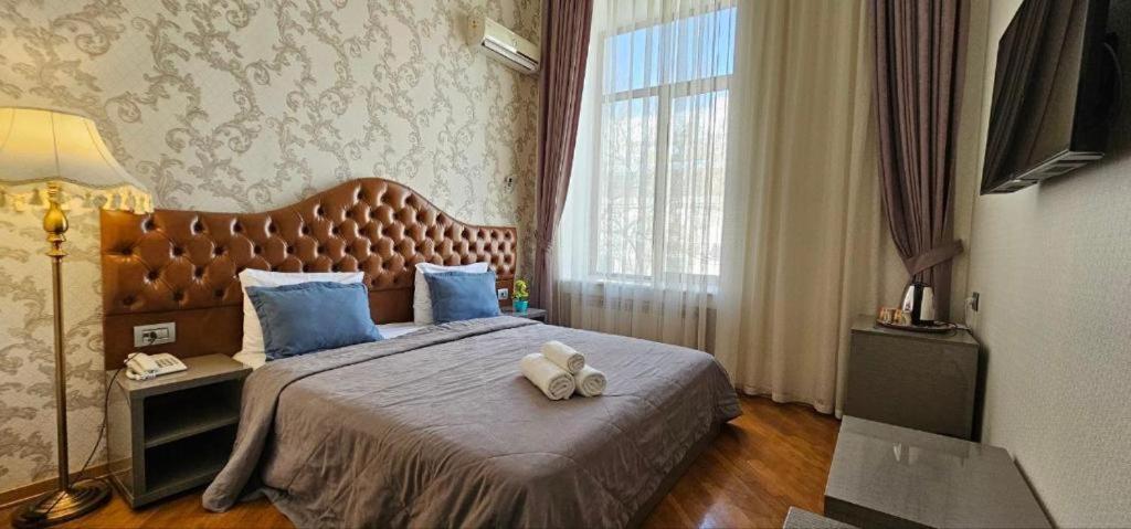 a bedroom with a large bed with blue pillows at Pilot Baku hotel in Baku