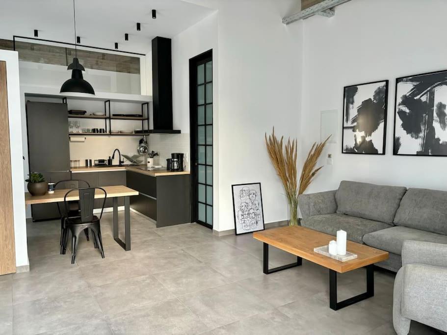 - un salon avec un canapé et une table dans l'établissement Industrial Loft Comfort Living, à Héraklion