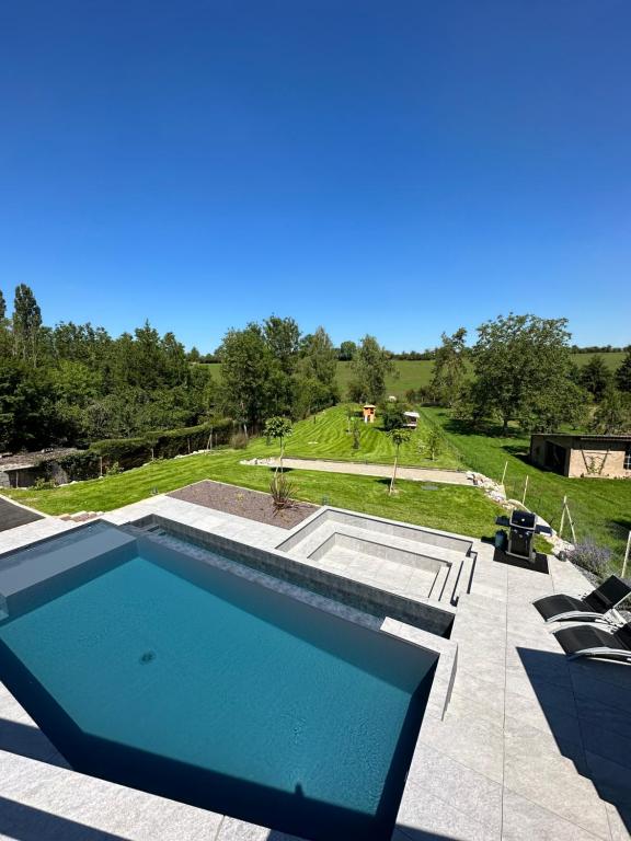 einen Pool auf einer Terrasse neben einem Hof in der Unterkunft Villa privée 230m2/ Piscine débordement/Billard-Babyfoot-Boulodrome-Flipper/Strasbourg in Dettwiller