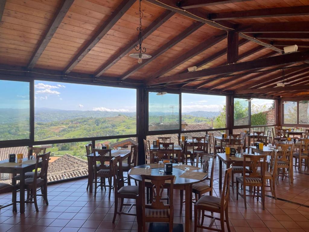 restauracja ze stołami i krzesłami z widokiem w obiekcie Albergo Diffuso Belvedere w mieście Alice Bel Colle