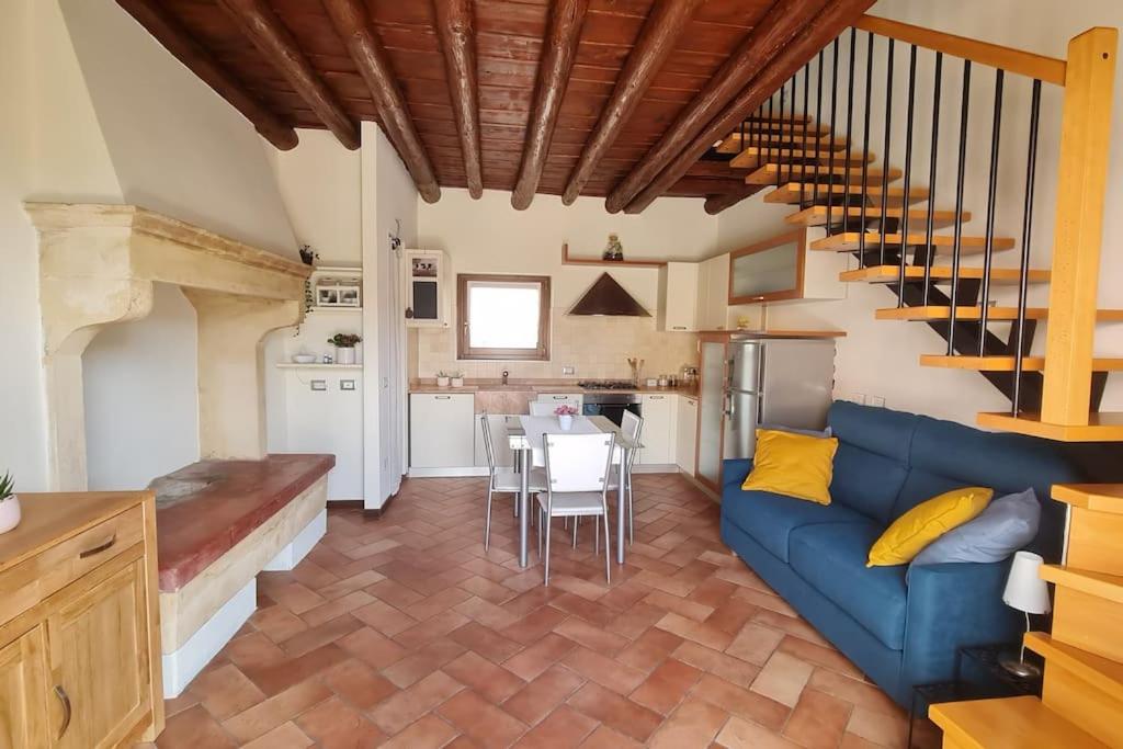 een woonkamer met een blauwe bank en een keuken bij Corte primavera. Custoza, lago di Garda, Verona in Villafranca di Verona