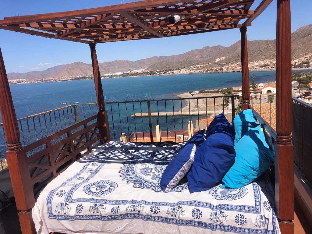 a bed on a balcony with a view of the water at PENTHOUSE A 50m DE LA MER! in La Azohía