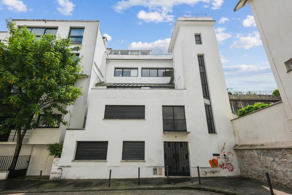 an apartment building with a white facade at Appartement atypique à Montsouris by Weekome in Paris