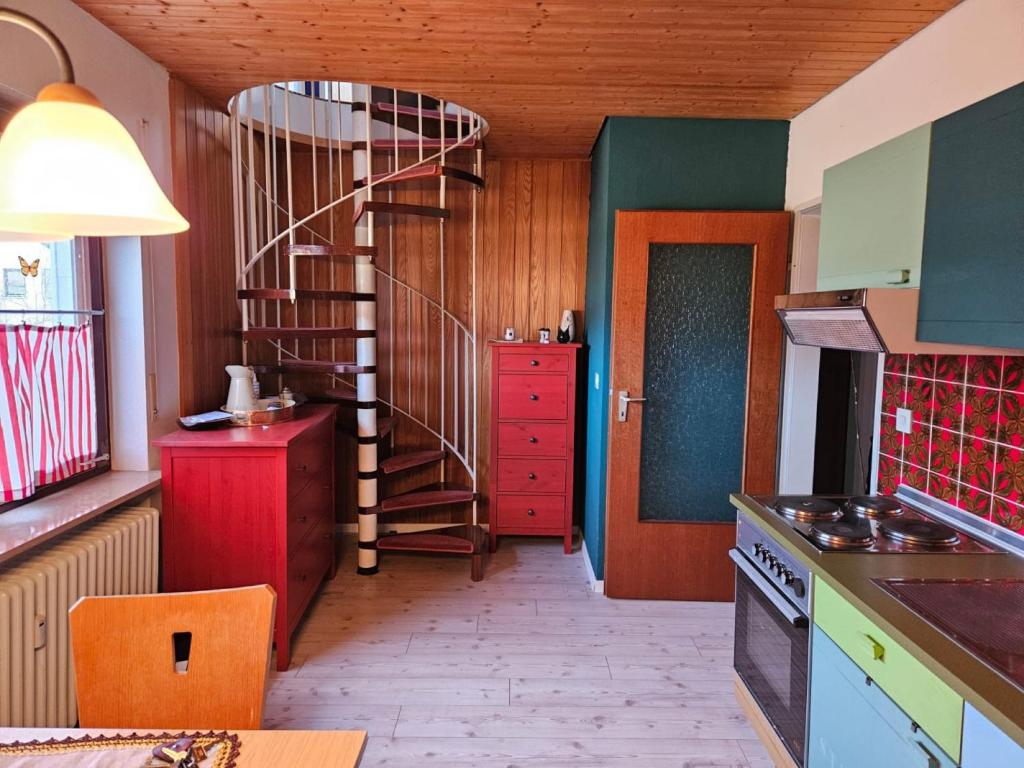 uma cozinha com uma escada em espiral num quarto em Ferienwohnung Maria 5 em Haundorf