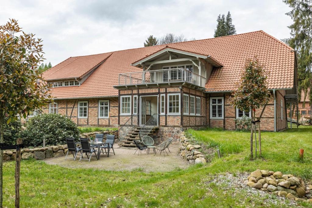 a large brick house with a patio and chairs at Suite mit Wintergarten in Dedelstorf